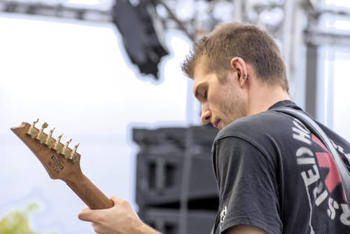 Reviewer's submitted photo showing a person playing an electric guitar outdoors.
