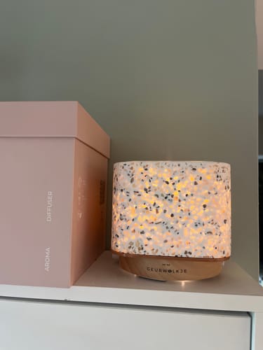 Recensent toont een verlichte diffuser in terrazzo-stijl die wordt gebruikt met de Vanille etherische olie.