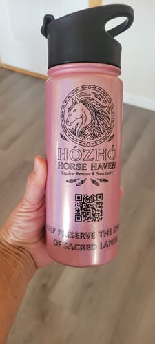 Customer holding a pink water bottle with a black Custom Printed Die Cut Decal of a horse logo.