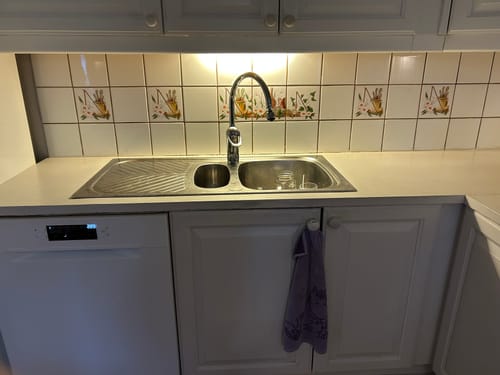 Nærbilde av den fornyede kjøkkenbenken med en lys kontaktplast rundt vasken.