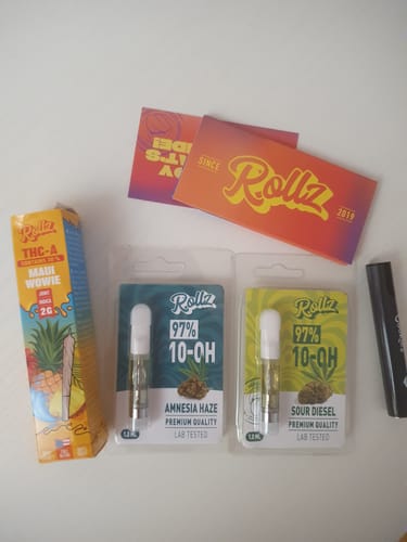 Customer's two 10-OH HHC Live Resin Cartridges in 'Amnesia Haze' and 'Sour Diesel' packaging, arranged on a surface.