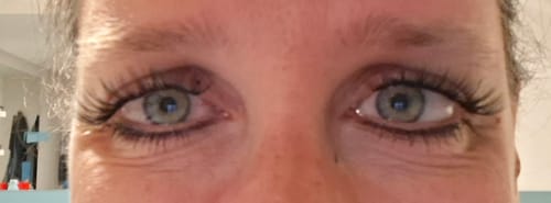 Rezensentin zeigt in einer Nahaufnahme ihre Augen mit dichten, schwarzen Wimpernextensions, die mit dem Love & Let Go Bundle angebracht wurden.
