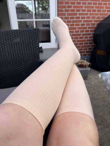 Kunde slapper af udendørs iført de lyse, tynde støttestrømper.