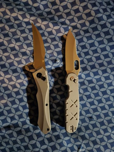 Reviewer's Hendrix Titanium Hell Hawk Switchblade, left, compared to another knife on a patterned surface.