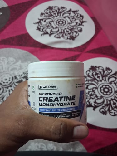 Customer holding the white tub of Wellcore Micronised Creatine Monohydrate in their hand.