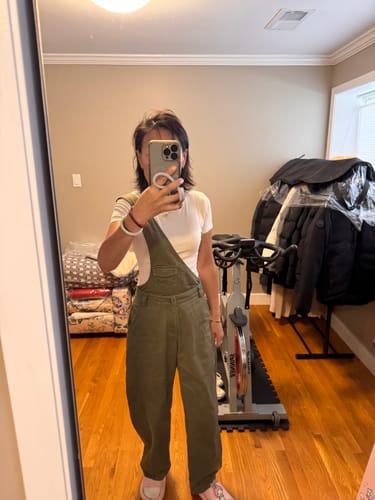 Customer taking a mirror selfie wearing the green one-strap overalls jumpsuit.