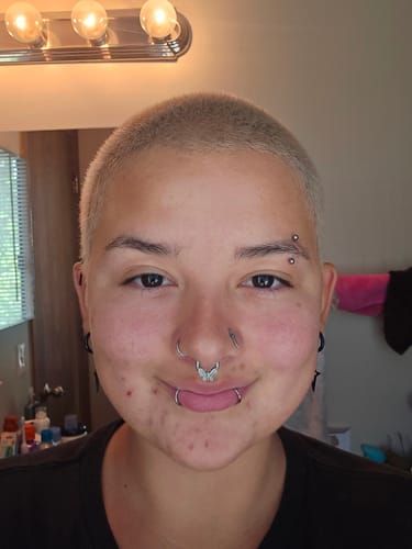 Customer smiling while wearing the silver-colored Butterfly Septum.