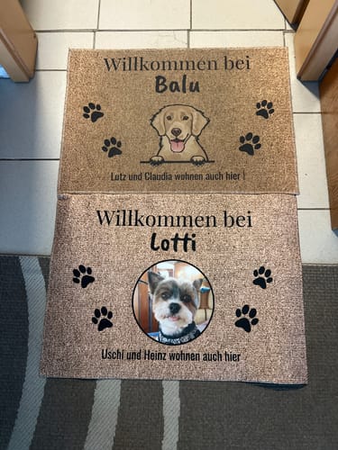 Kunde zeigt zwei personalisierte Fußmatten, eine mit einer Hunde-Illustration und eine mit einem Foto.