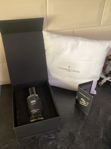 Reviewer's Lilium Blume Eau de Parfum in its elegant black box with a branded pouch and card nearby.