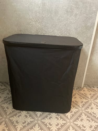 Kundens sorte Gio skittentøyskurv står på et mønstret flisgulv på badet.