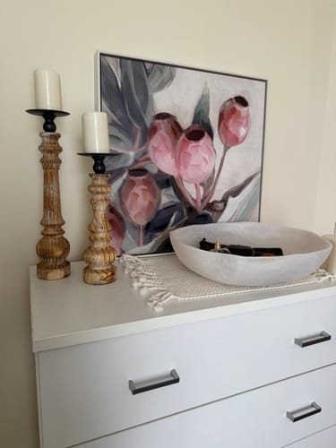 Customer's two turned timber Jean pillar candle holders of different heights styled on a white dresser.