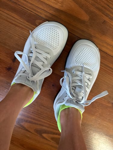Customer's top-down view of the white CUURT Muuv court shoes, showing the wide toe box and neon ankle accent.