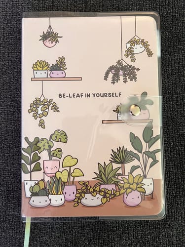 Reviewer's clear PVC journal cover shown protecting an illustrated journal with cute plant designs.