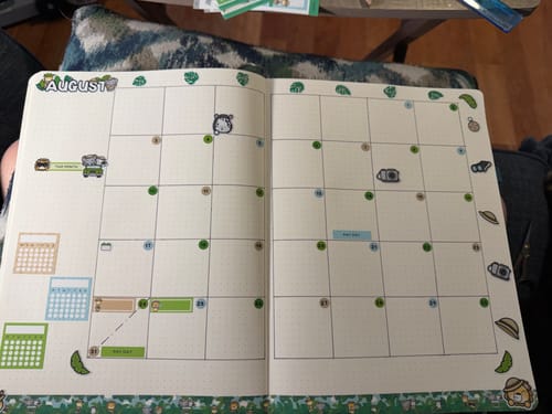 Customer's open journal with an August calendar decorated with safari-themed stickers and washi tape from their Ultimate Subscription.