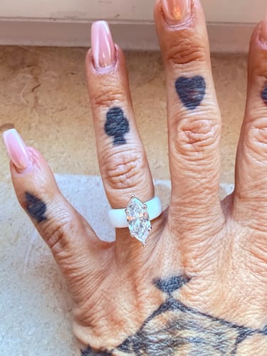 Reviewer wearing the white Silicone Ring with a marquise-cut stone on a tattooed hand.