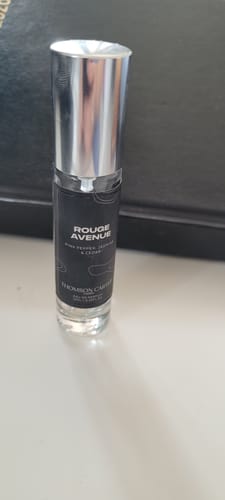 Customer's nearly empty bottle of Rouge Avenue Eau de Parfum with a shiny silver cap, standing on a white surface.