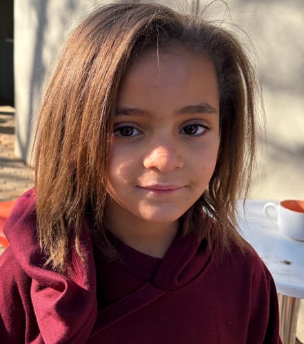 Customer's photo of their daughter's hair, appearing smoother after using Brasil Cacau Extreme Repair Shampoo.
