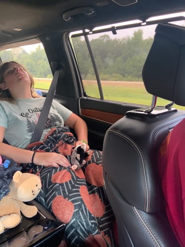 Customer's granddaughter wearing the Go Outside T-shirt while sleeping comfortably in a car.
