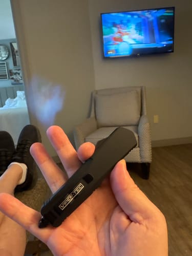 Customer's hand holding a black Viper Tec OTF knife in a retracted position inside a room.