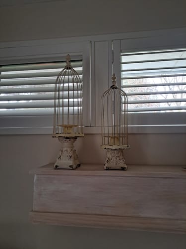 Customer's pair of François birdcage candle holders displayed on a white mantel in front of a window.