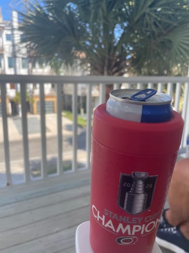 Reviewer's red Carolina Hurricanes Universal Buddy holding a beverage can on a porch.