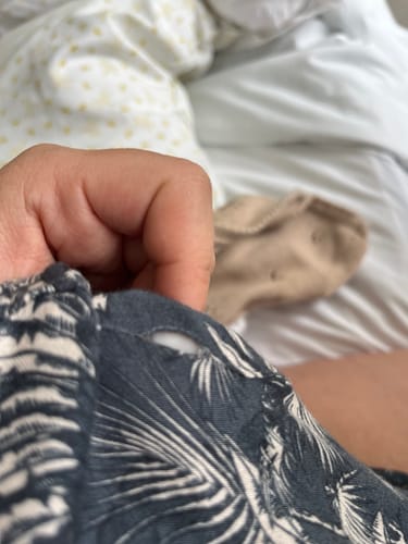 Primer plano de un cliente mostrando un pequeño agujero en la tela de su Camisa de Dormir Palmeras Dreamy.