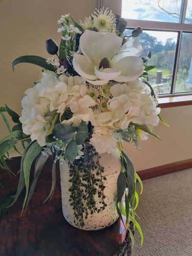 Customer's Serge Distressed White Milk Churn Vase with a large arrangement of white flowers and greenery on a table.