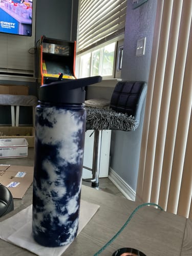 Customer's blue and white tie-dye tumbler from their Mystery Buddy Box sitting on a table.