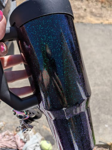 Customer holding their Mermaid Thicc Buddy 40oz mug, showing the sparkly finish and keys on the handle.