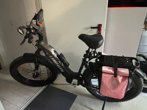 Customer's grey Lankeleisi MG600 Plus e-bike parked indoors, shown from the side with a pink pannier bag on the rear rack.