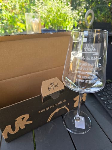 Rezensent zeigt das personalisierte Leonardo Weinglas mit der Gravur "Genieße den Ruhestand" neben der Geschenkverpackung.