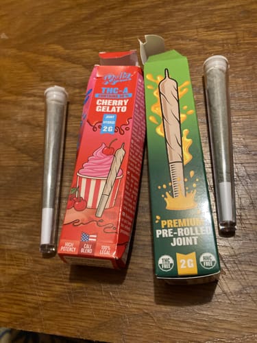 Customer's two Rollz THCA Pre-Rolls in colorful boxes, including the Cherry Gelato strain, next to their individual tubes.