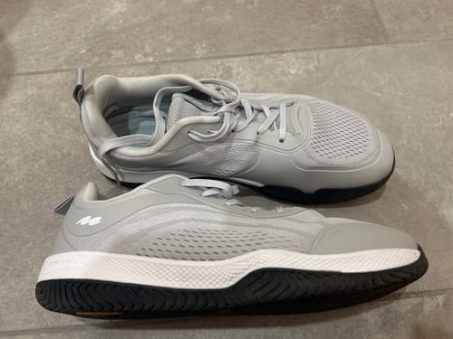 Reviewer's pair of light grey CUURT Muuv court shoes displayed on a tile floor, showing top and side views.