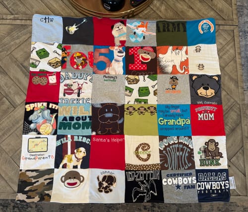 Customer's custom baby blanket, a colorful quilt made from patches of their child's shirts, onesies, and clothes.