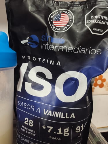 Bolsa de Proteína Aislada ISO sabor Vainilla de un cliente, junto a un vaso mezclador.