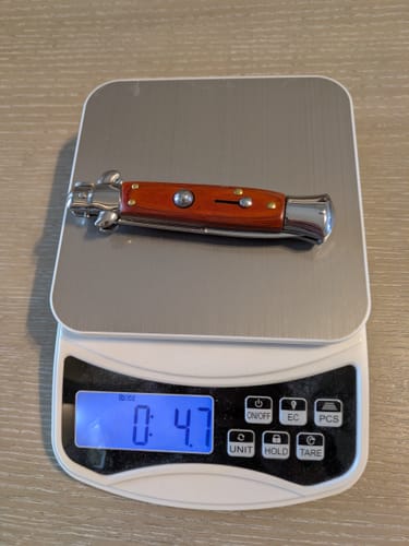 Customer's Woodsman Stiletto knife resting on a digital scale showing a weight of 4.7 ounces.
