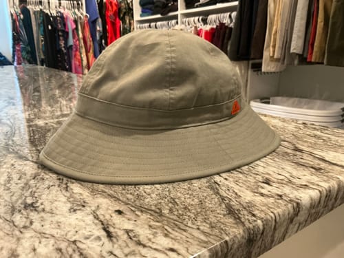 Customer's Big Round Bucket Hat, olive green cotton style, sitting on a marbled kitchen counter.