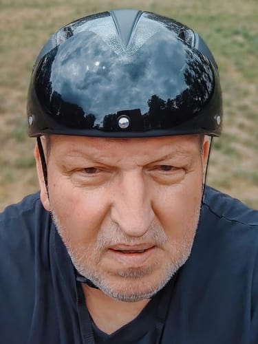 Customer's face wearing the black Vakole bicycle helmet with the magnetic goggles lowered.