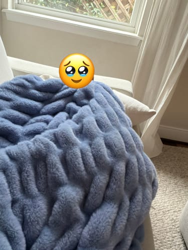 Customer's Hugs Light Caribbean Blue blanket draped over a chair, showing its soft, textured fabric.
