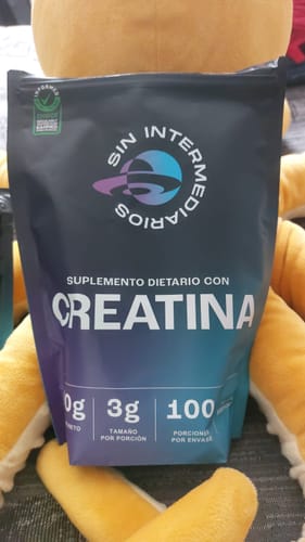 Customer's Creatina Monohidrato pouch held in front of a yellow plush toy.