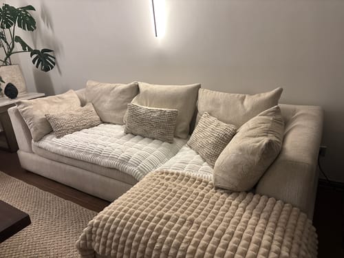 Sofá seccional claro en L con cobertura diferenciada en asiento principal y chaise