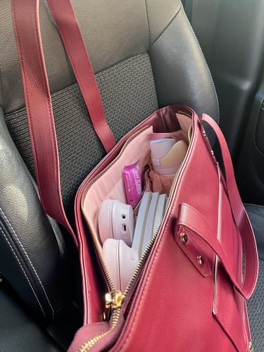 Customer's The One Tote filled with personal items, sitting on a car seat