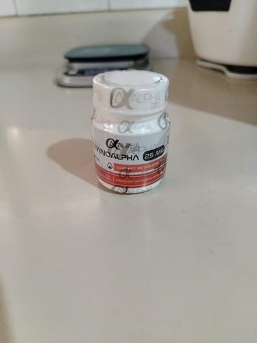 Customer's Stanoalpha 25mg bottle, part of the Ciclo Definición oral set, standing on a light counter.