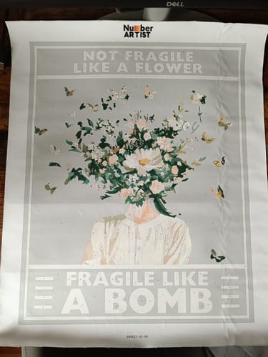 Reviewer's wrinkled Fragile Like a Bomb paint by numbers canvas showing a floral design, displayed flat.