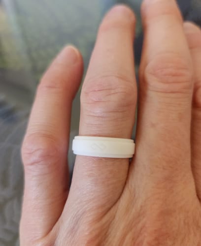 Customer's white silicone GIFT RING on their finger, showing the infinity symbol detail.