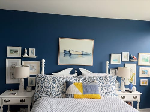 Customer's Harbor Rest Canvas Art hanging centered above a bed on a dark blue wall in a nautically styled room.