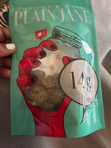 Customer's hand holding a sealed 14g package of Bubba Fett THCA Flower with a colorful illustration.