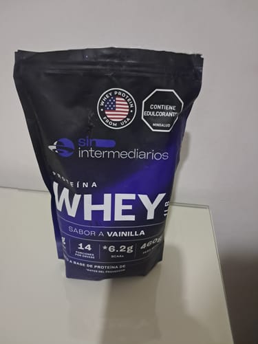 Customer's Proteína Whey, a black bag of vanilla flavor powder standing on a white surface.