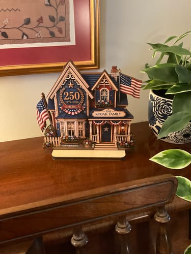 Customer's personalized wooden 2-layered house plaque, celebrating America 250, displayed on a wooden piano.