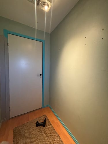 Customer's rom før installasjon av Oslo mini selvklebende fliser, med tomt gulv og lyseblå vegger.